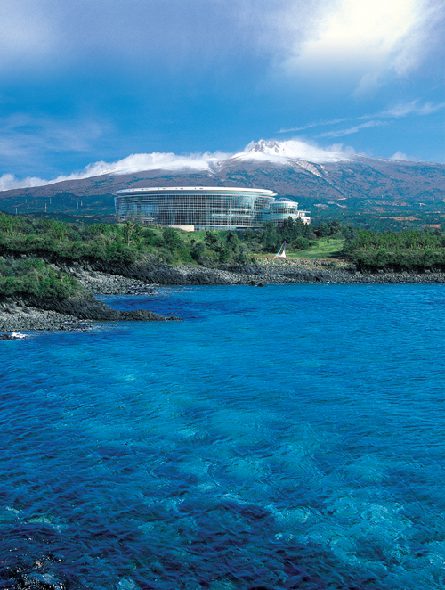 The ICC Jeju convention centre on the coast with Hallasan behind it